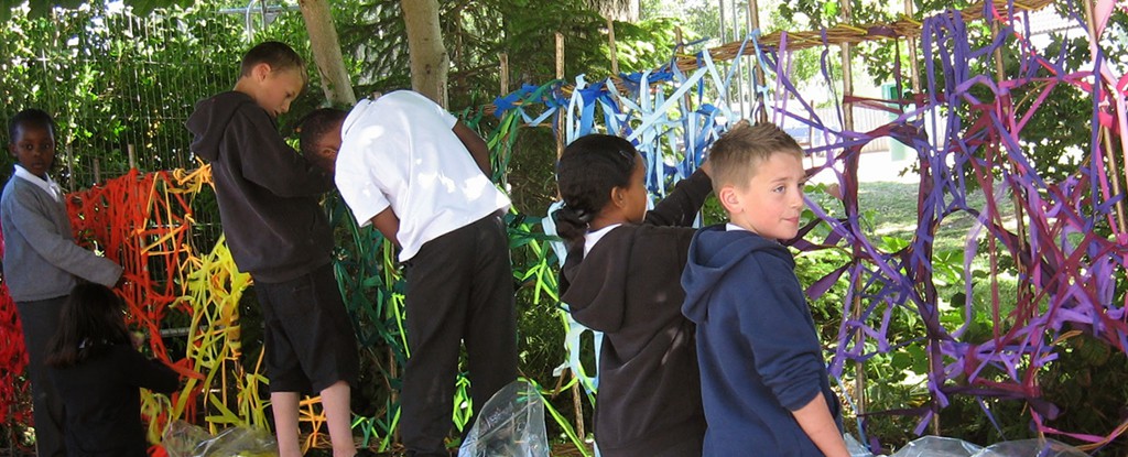 Sarah Jayne Edwards creating a colourful willow  weaving sculpture with students. 